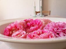 Pink roses lying in earthenware dish as decoration