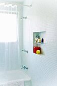 Square wall niche in a mosaic tiled bathroom
