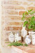 Mediterrane Kräuter & Olivenöl in Metalldosen auf gemauerter Ablage im Château Maignaut (Pyrenäen, Frankreich)