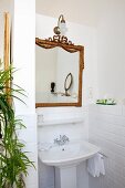 Antique mirror above pedestal sink