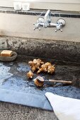 Jerusalem artichoke tubers and handled brush in stone sink