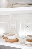 Glass vessels and white crockery on shelves