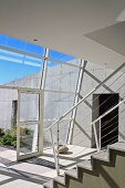 Staircase in contemporary building with glass wall and view into courtyard