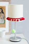 Table lamp decorated with pompom trim & pompom on light pull