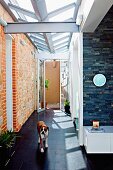 Bright hallway with skylight and one stone wall; dog in foreground