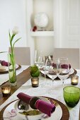 Windlichter und Vase mit Tulpe auf gedecktem Tisch
