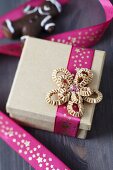Pink ribbon with pattern of stars and cardboard bow on gift box