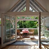 Soaking up the sun on a balcony - attic room with open balcony door and view of sunny balcony with table and chairs