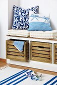 White seat cushions and blue and white scatter cushions on storage bench