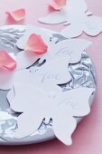 Paper butterflies & rose petals decorating table