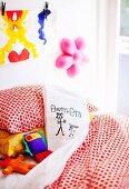 Von Kindern selbstbemaltes Kissen auf Bett in Kinderzimmer