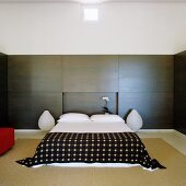 Japanese simplicity in bedroom with smooth wall panelling and rice paper lamps