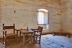 Adobe walled room with rough hewn table and chairs at Mission La Purisima State Historic Park, Lompoc, California