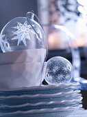 Transparent glass Christmas baubles on stack of plates