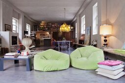 Lime green beanbag armchair and collection of different lamps in large, open-plan loft apartment