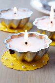 Small cake moulds used as tealights on doilies