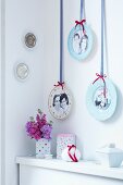 Gallery of photos on plates hung on wall by decorative ribbons