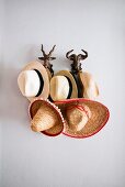 Panamahüte und Sombreros an Garderobenhaken in Form von Wildtierköpfen
