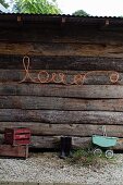 Flexible light strip spelling the word 'Love' on exterior wall of wooden cabin