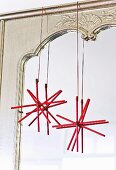 Selbst gebastelte Weihnachtssterne aus Holzstäbchen vor einem Spiegel