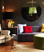 Bright scatter cushions and lustrous green pendant lamp providing accents of colour combined with sofas in muted colours and anthracite walls