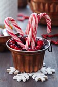 Candy canes and decorative wreath of berries in copper jelly mould