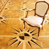 Rococo chair on parquet floor with marquetry compass pattern