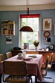 Vintage-Küche mit blauen Wänden, roten Farbakzenten und Essplatz mit Freischwingerstühlen aus den Sixties