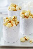 Mit Spitzenbordüre umwickelte Muffinförmchen als kreativ gestalteter Behälter für Popcorn