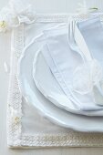Mit Bordüre und Spitzenblüte verziertes Stoffset für ein romantisches Tischgedeck