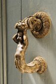 Artistically hand-crafted bronze figurine as handle on wooden door