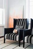 Elegant armchairs upholstered in black leather and geometric, black and white patterned fabric