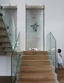 Steintreppe mit läuferartigem Holzbelag und Glas Brüstungsgeländer, Tierzeichnung an Glasscheibe, im Hintergrund kleines Mädchen