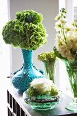 Various flowers in glass vases and blue ceramic vase
