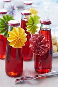 Small bottles of cherry drinks with paper rosettes