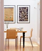 Modernes Esszimmer mit Wandbildern, Holztisch mit gedrechselten Tischbeinen & Korbstühlen