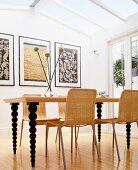 Modernes Esszimmer mit Deckenfenstern, Korbstühlen & Esstisch aus Holz mit gedrechselten Tischbeinen