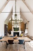 Open-plan, modern interior in converted barn with loft atmosphere with exposed beams and exposed masonry in background