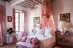 Romantisches Schlafzimmer mit rotweißem Toile-de-Jouy für Vorhänge, Kleiderbank, Kissen und Betthimmel im Shabby-Chic Flair