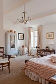 Geräumiges Schlafzimmer mit antikem Schreibtisch und Armlehnstuhl im romantischen Landhauslook