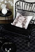 Scatter cushion with print portrait (Kate Moss) on black wicker chair, disco balls and vase on side table
