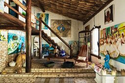 Rustic interior with brick floor and round timber gallery; Brazilian paintings and altar table with figures in shades of blue venerating the sea goddess Lemanja