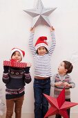 Children holding up Christmas decorations