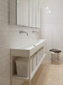 Langer Waschtisch mit Aufbewahrungskörben in weißem, minimalistischen Badezimmer mit verspiegeltem Hängeschrank
