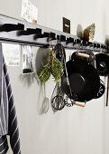 Cooking and baking utensils hanging from black hook rack