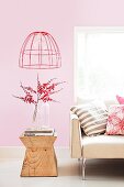 Sofa and wooden side table in interior with pink walls