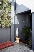 Corner of terrace with vertical planting and outdoor shower in niche