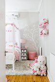 Fröhliches Kinderzimmer in Grau und Rosa mit einer großen Stofftiersammlung und einem hellen Holzdielenboden