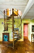 Wendeltreppe durch einfache Holzdecke in hellgrün getöntem Wohnraum