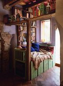 Comfortable reading area with built-in bookcase next to window in renovated, Mediterranean country house